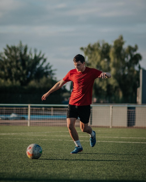 Vertikale Aufnahme eines Spielers, der einen Fußball kickt.