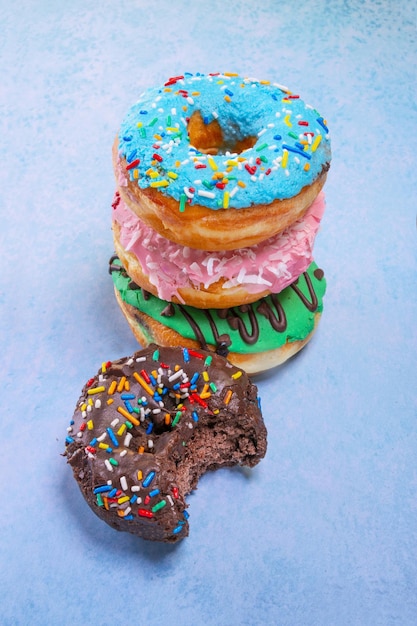 Vertikale Aufnahme von bunten Donuts auf blauem Hintergrund