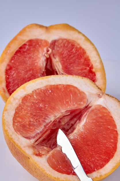 Vertikale Aufnahme von Grapefruit, die mit einem chirurgischen Untersuchungskonzept des Skalpells auf zwei Stücke geschnitten wurde