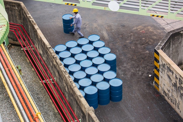 Vertikale Bewegung der Ölfässer von oben für die männliche Arbeiterhilfe beim Arrangieren.