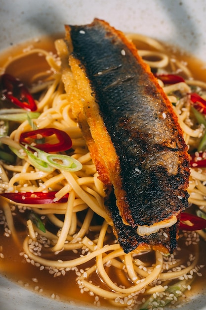 Vertikale Nahaufnahme einer Ramen-Suppenschüssel mit Lachs