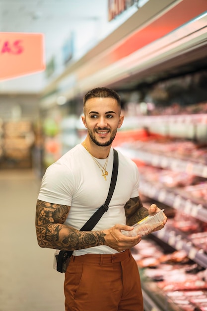 Vertikale Nahaufnahme eines Kaukasiers, der Fleisch im Lebensmittelgeschäft kauft