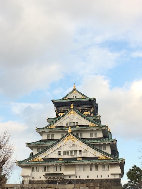 Vertikale Niedrigwinkelansicht des Schlosses von Osaka unter dem bewölkten Himmel