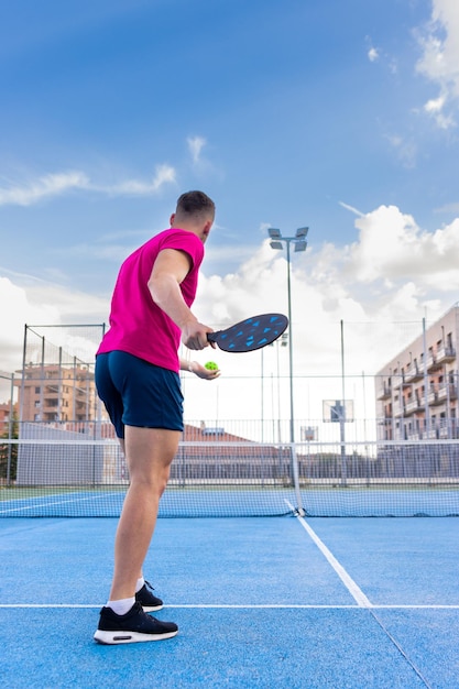 Vertikale seltene Ansicht eines Pickleball-Spielers, der bereit ist, den Auftrag in einem Pickleball-Training auf einem Außenplatz zu realisieren