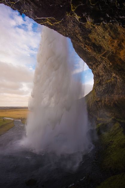 Foto vertikale von schönen wasserfällen in island mit bewölktem tag