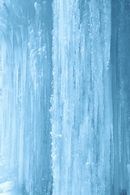 Vertikaler Hintergrund von Eiszapfen auf gefrorener Wasserfallwand