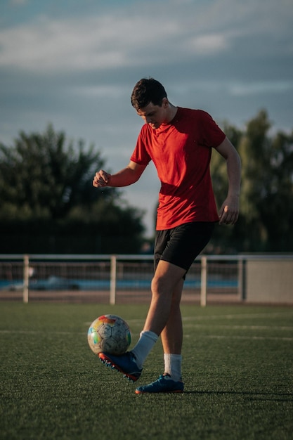 Vertikaler Schuss eines Spielers, der mit seinen Füßen auf dem Fußballfeld berührt.