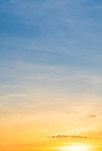 Vertikaler Sonnenunterganghimmel am Abend mit bunten orangefarbenen Sonnenlichtwolken zur goldenen Stunde