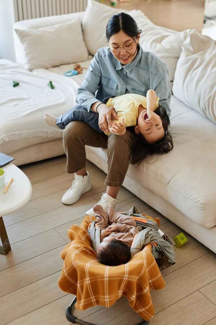 Foto vertikales bild einer asiatischen mutter, die mit ihren kindern im heimischen wohnzimmer spielt