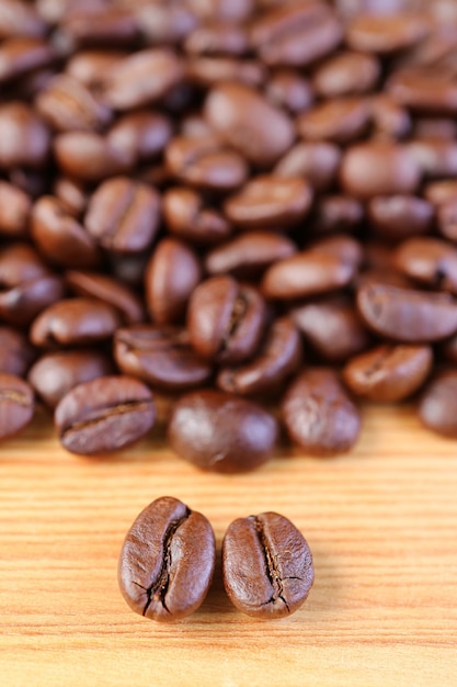 Vertikales Bild von Arabica VS Robusta gerösteten Kaffeebohnen mit verschwommenem Kaffeebohnenstapel im Hintergrund