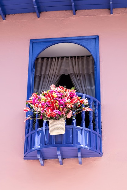 Vertikales Foto der antiken lateinischen Architektur eines Fensters, das in Dunkelblau und Pastellrosa gemalt wurde