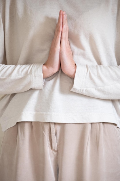 Vertikales Foto einer Frau, die Namaste mit Kopierraum macht