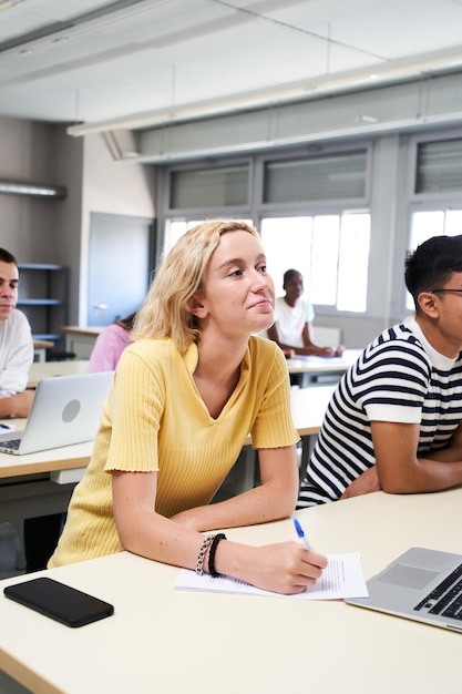 Foto vertikales foto einer naturwissenschaftlichen klasse einer highschool, bei der ein junge und ein mädchen einen laptop verwenden, während sie teilnehmen