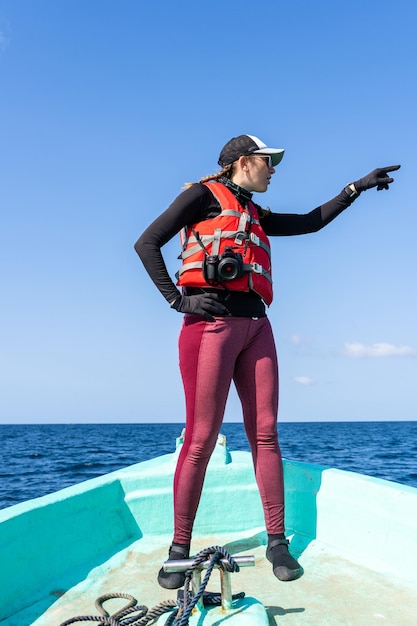 Vertikales Foto eines Biologen auf einem Boot mit Kamera