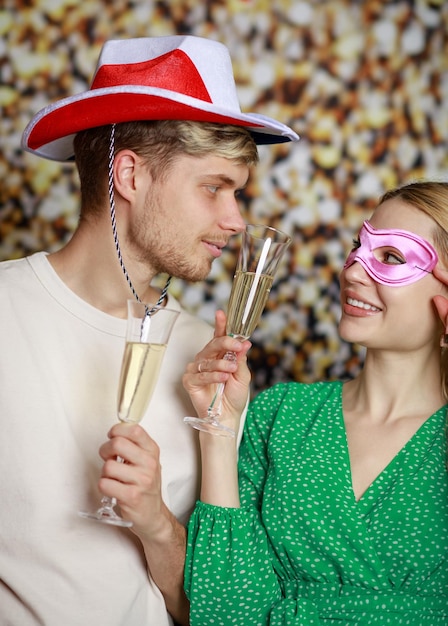 Vertikales Foto eines jungen Paares, das Champagner trinkt