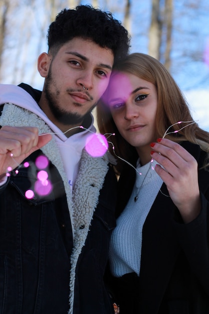 Vertikales Porträtbild eines jungen verlobten Paares mit einem Weihnachtskranz
