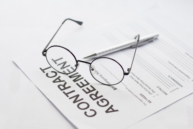 Foto vertragsunterzeichnung mit brille und stift in der nähe