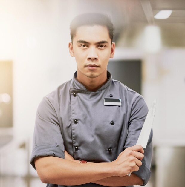 Foto vertrauen in die küche abgeschnittenes porträt eines jungen männlichen kochs, der mit einem messer in seiner küche steht
