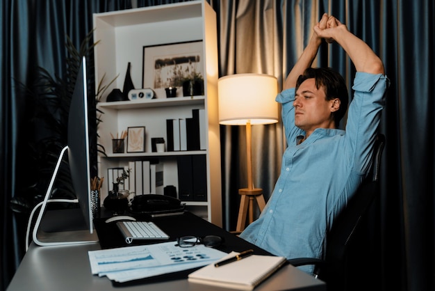 Vertriebsleiter arbeitet mit Dehnungsmethode bei der Nachtarbeit