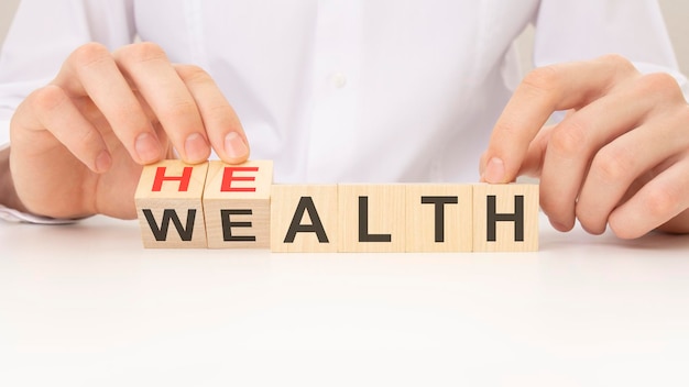 Verwandeln Sie die Botschaft auf dem Holzblock von Gesundheit zu Wohlstandsgesundheitskonzept und einer nachhaltigen finanziellen Zukunft