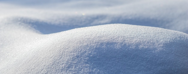 Verwehungen von frischem Schnee, der an einem frostigen Tag Naturwinterhintergrund in der Sonne funkelt