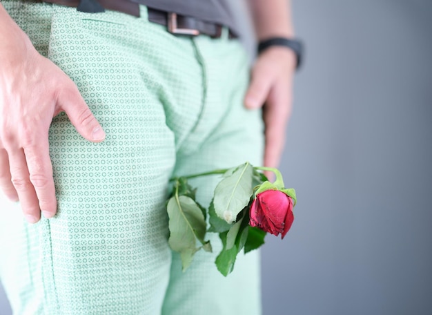 Verwelkte Blume zwischen den Beinen des Mannes, Nahaufnahme