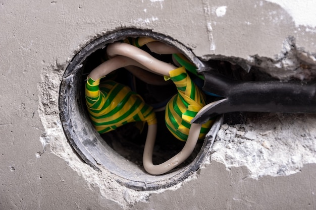 Verwenden einer isolierenden Anschlussklemme oder einer verdrehten Anschlussdrahtmutter, um elektrische Leitungen in einer Verteilung an einer Betonwand anzuschließen