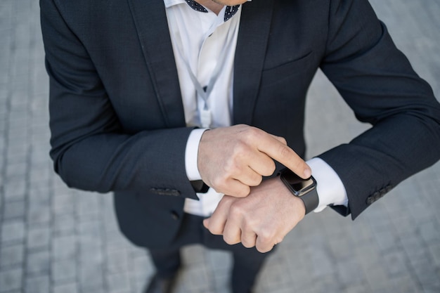 Verwendet einen Smartwatch-Geschäftsführer in einem Business-Anzug im Büro