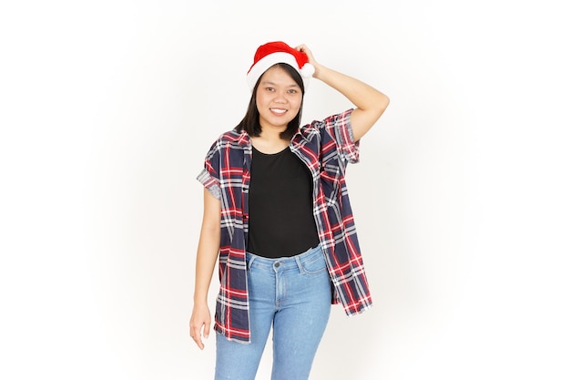 Verwirrte Geste der schönen asiatischen Frau mit rotem kariertem Hemd und Weihnachtsmütze, isoliert auf weiss