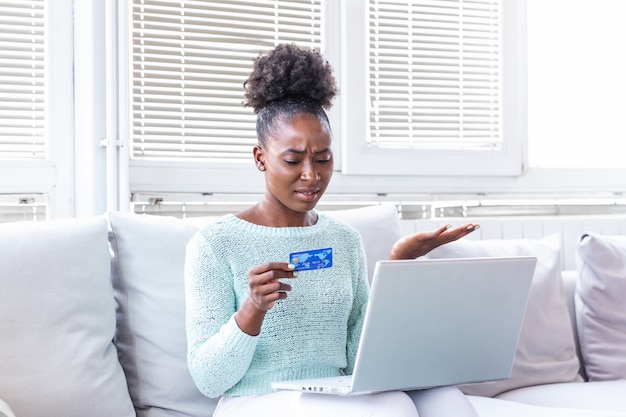 Verwirrte junge Frau, die Probleme mit Kreditkarte hat
