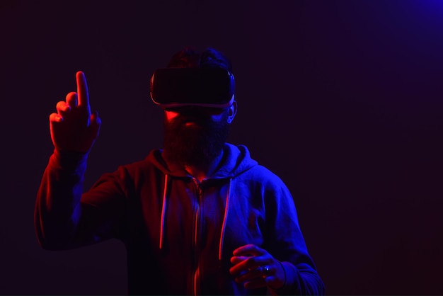 Verwirrter bärtiger Mann in Virtual-Reality-Headset weist auf zukünftiges zukünftiges Technologiekonzept hin