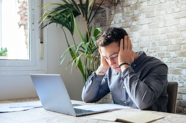 Verwirrter, frustrierter junger Mann liest Brief, Schuldenbenachrichtigung, schlechter Finanzbericht, Geldproblem, Geldproblem, verärgerter Student, der schlechte Nachrichten erhält, erfolglose Prüfungs- oder TestergebnissexA
