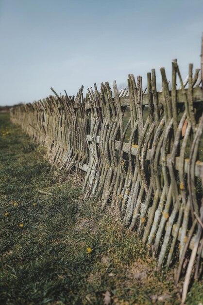 Foto verwitterter zaun auf dem feld gegen klaren himmel.