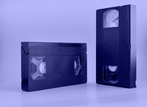 Very pery El color del año 2022 Dos viejas cintas de casete vhs vintage negras recortadas 80s 90s medios retro estéticos cinta de video magnética concepto de almacenamiento de películas tiro del estudio