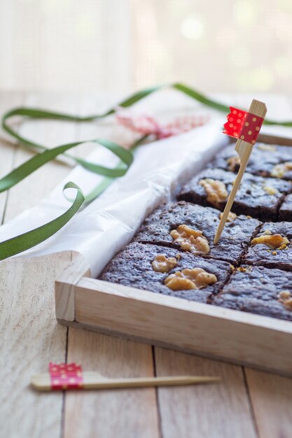 Verzierte Schokoladenbrownies mit Walnuss in der Holzkiste