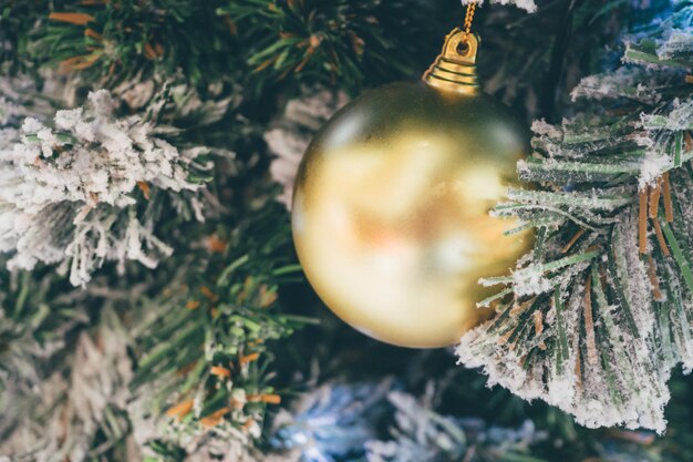 Verzierter Weihnachtsball auf Tannenbaum-Neujahrsfeiertagshintergrund