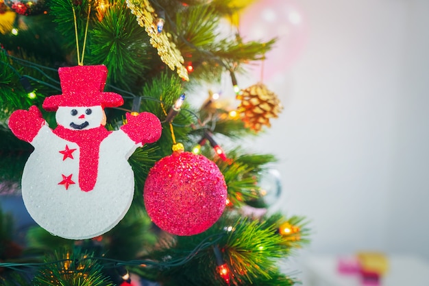 Verzierter Weihnachtsbaum mit dem Hängen des roten Balls, Schneepuppe