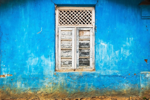 Verziertes Fenster auf blauer Wand