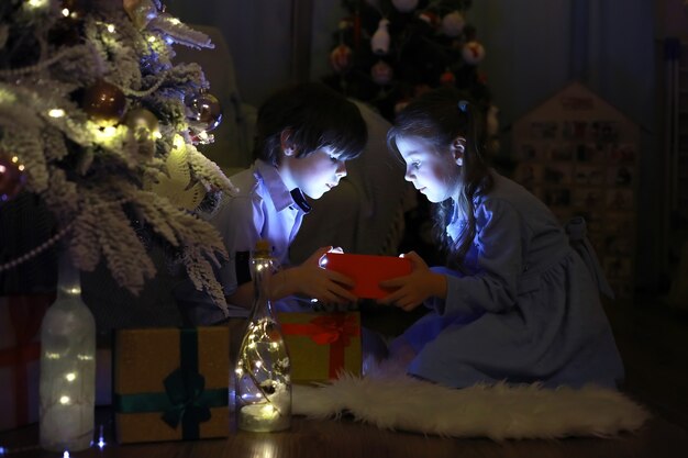 Véspera de Ano Novo. A casa está decorada para o feriado. Árvore de Natal elegantemente vestida com uma guirlanda e uma família com presentes e uma surpresa.