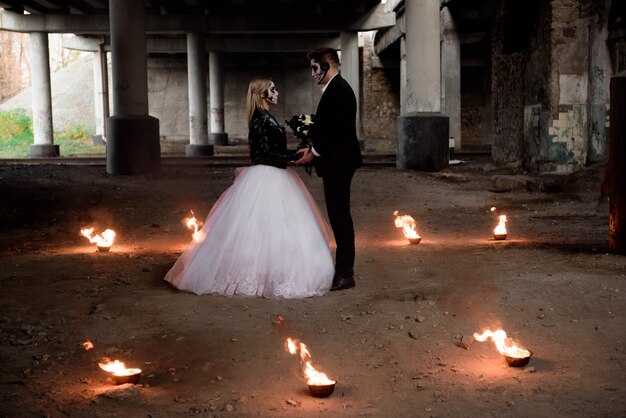 Vestida com roupas de casamento casal zumbi romântico.