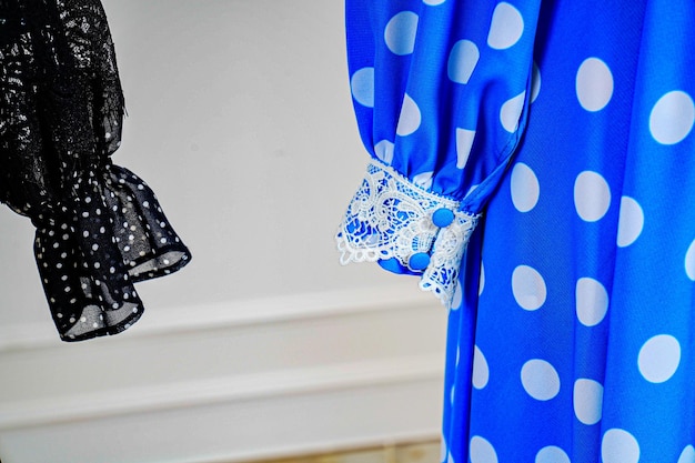 Un vestido azul con lunares blancos se exhibe en una habitación.