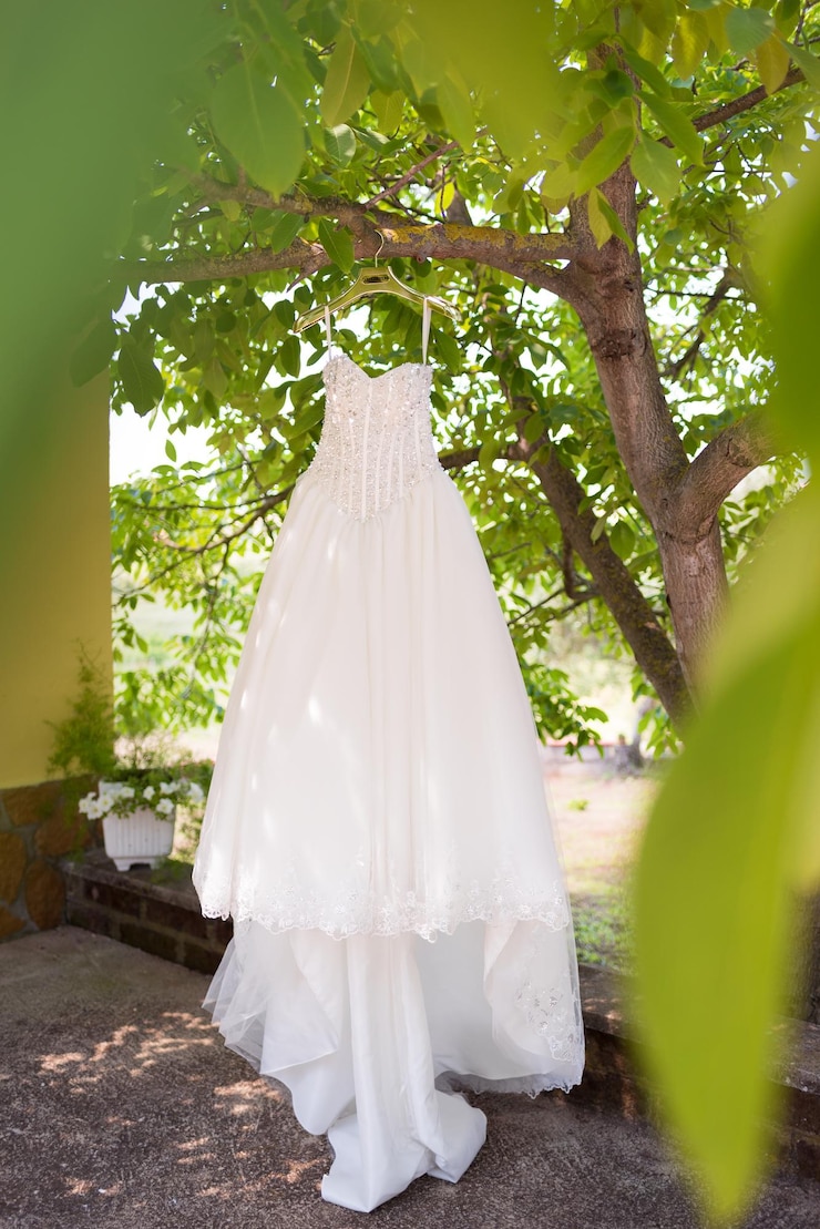 Foto el vestido blanco colgado en el árbol