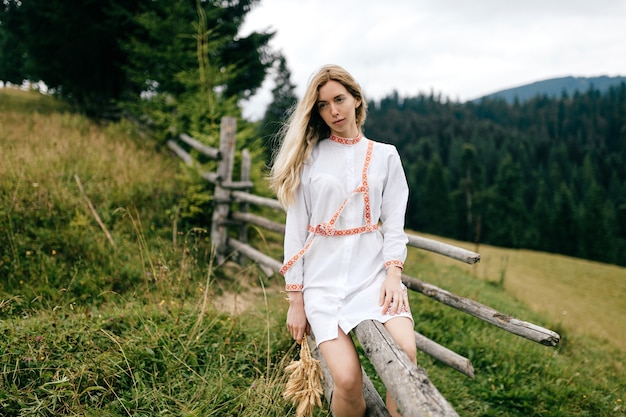 Vestido blanco joven atractiva mujer rubia con adorno