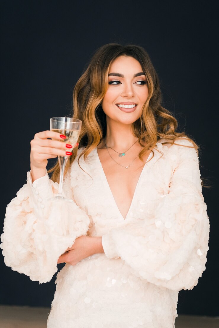 Vestido brilhante de mulher bonita segurando uma taça de champanhe fundo preto