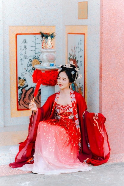 Vestido de mujer China retrato de año nuevo de una mujer en traje tradicional mujer en vestido tradicional hermosa mujer joven en un vestido rojo brillante y una corona de reina china posando