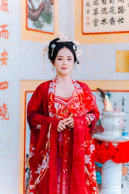 Vestido de mujer China retrato de año nuevo de una mujer en traje tradicional mujer en vestido tradicional hermosa mujer joven en un vestido rojo brillante y una corona de reina china posando