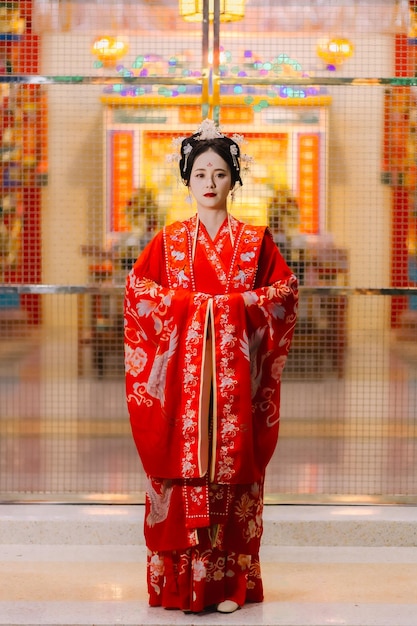 Foto vestido de mujer china retrato de año nuevo de una mujer en traje tradicional mujer en vestido tradicional hermosa mujer joven en un vestido rojo brillante y una corona de reina china posando