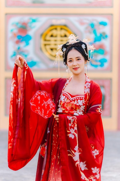 Foto vestido de mujer china retrato de año nuevo de una mujer en traje tradicional mujer en vestido tradicional hermosa mujer joven en un vestido rojo brillante y una corona de reina china posando