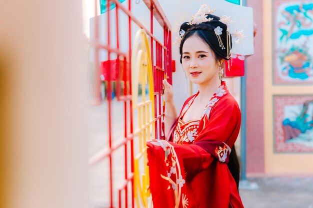 Foto vestido de mujer china retrato de año nuevo de una mujer en traje tradicional mujer en vestido tradicional hermosa mujer joven en un vestido rojo brillante y una corona de reina china posando