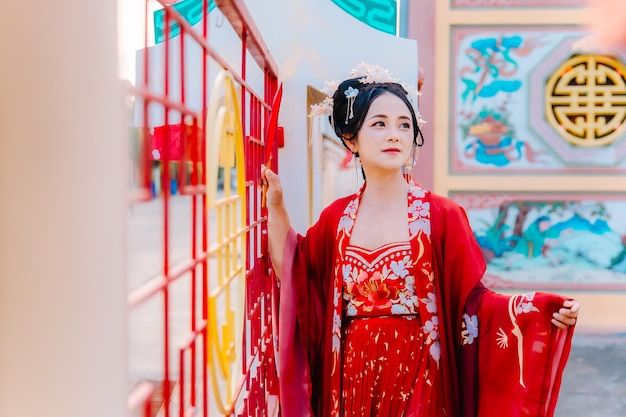 Foto vestido de mujer china retrato de año nuevo de una mujer en traje tradicional mujer en vestido tradicional hermosa mujer joven en un vestido rojo brillante y una corona de reina china posando